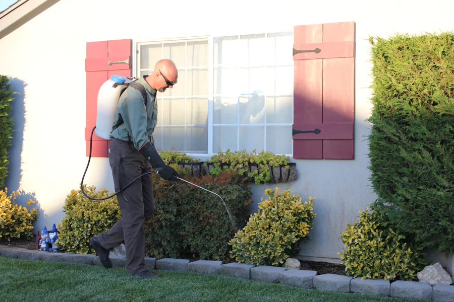 Technician treating the exterior foundation line of a house